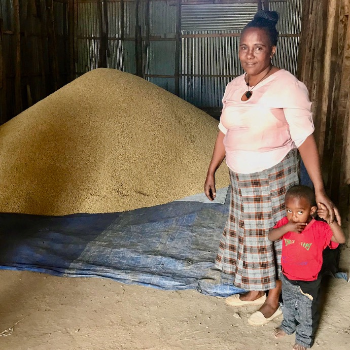 African Coffee farmer with her son and dried coffee beans