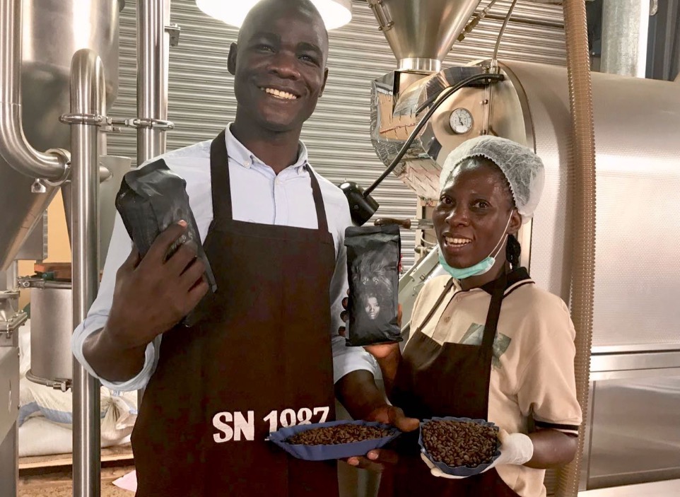 Two African Roasters smiling with bags of wild coffee in the hands