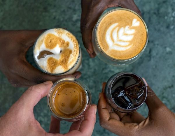 Four hands holding coffee