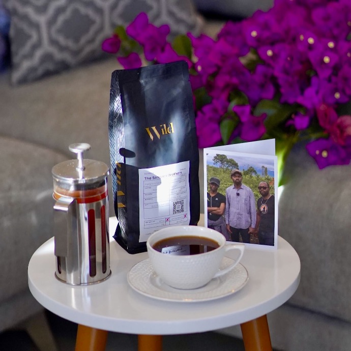 French press with a cup of coffee and a postcard representing African Coffee Farmers
